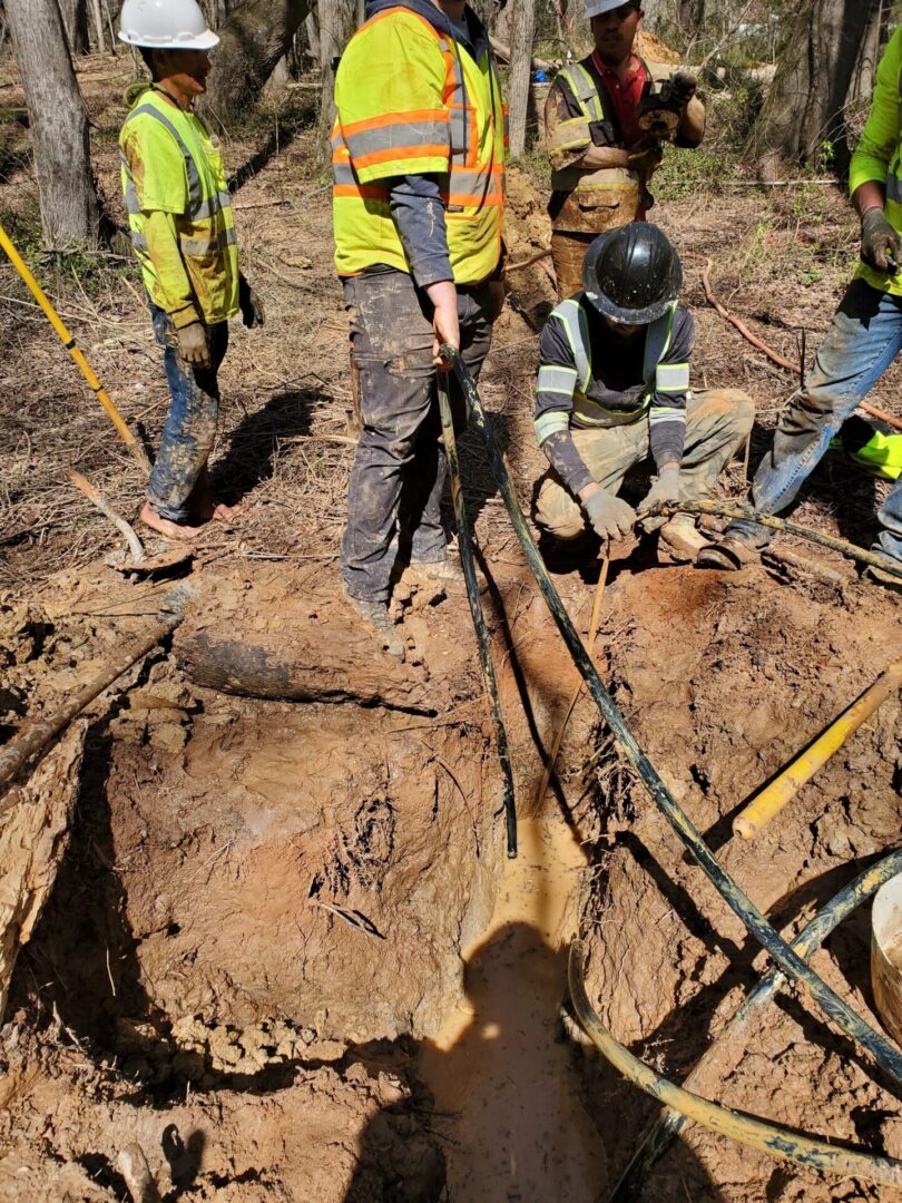 Workers repairing underground cables in forest